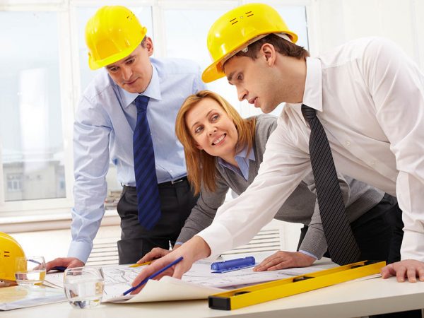 Three architects sitting at table and discussing project
