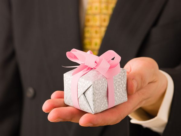Man on suit give a little gift for somebody