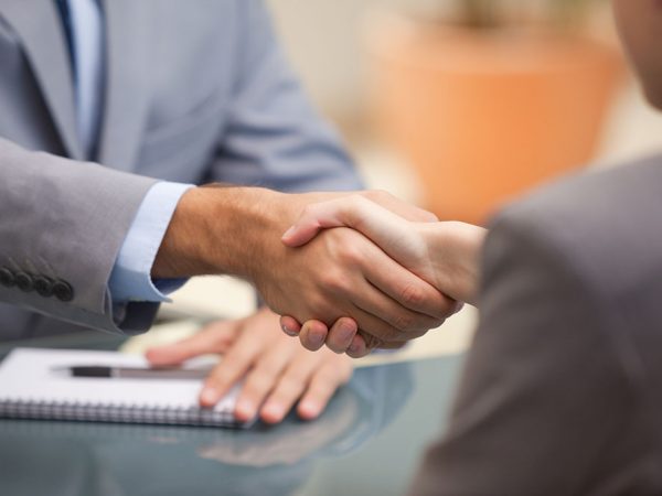 Two Businesspeople shaking hands indoors